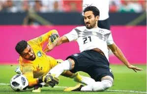  ?? TIMO SCHMUELGEN/REUTERS ?? SASARAN TEROR: Ilkay Guendogan (kanan) berusaha menaklukka­n kiper Arab Saudi Abdullah Al-Maiouf.