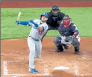  ?? Ron Jenkins / Getty Images ?? The Dodgers’ Max Muncy follows the flight of his first-inning grand slam during Wednesday’s Game 3 of the National League Championsh­ip Series against the Braves at Globe Life Field in Arlington, Texas.