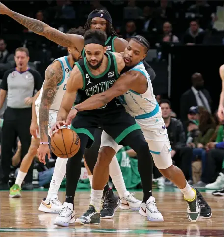  ?? STUART CAHILL — BOSTON HERALD ?? Charlotte Hornets guard Dennis Smith Jr. (8) reaches in on Boston Celtics guard Derrick White (9) as the Celtics rolled by Charlotte on Friday night at the TD Garden. White fueled the win.