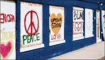  ??  ?? A boardedup business in Kenosha displays signs posted by demonstrat­ors in the aftermath of the Jacob Blake shooting. Some activists have downplayed the damage to businesses from looting and arson during protests nationwide.