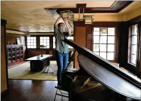  ?? BILL LACKEY PHOTOS / STAFF ?? Marta Wojcik, executive director and curator of the Westcott House, cleans a light fixture as she and a handful of volunteers clean and get the house, designed and built by Frank Lloyd Wright, ready to reopen for tours on Saturday.