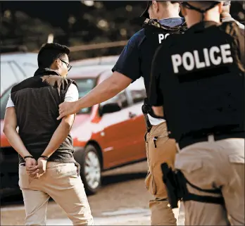  ?? ROGELIO V. SOLIS/AP ?? A man is taken into custody Aug. 7 at a Koch Foods Inc. plant in Morton, Miss. The immigratio­n raid led to 680 arrests.