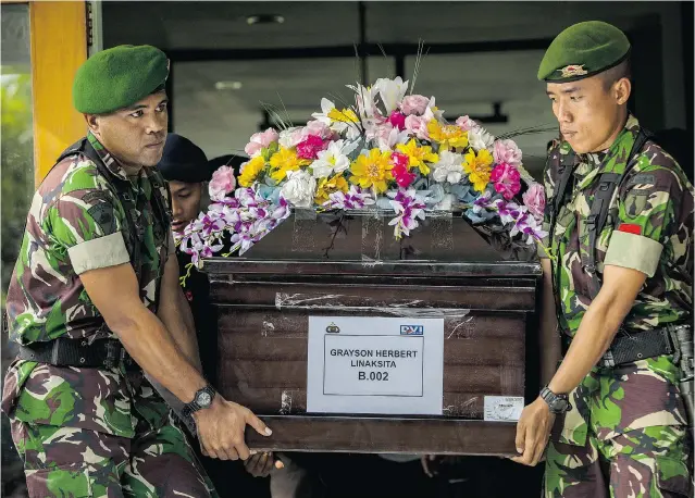  ?? OSCAR SIAGIAN/GETTY IMAGES ?? Indonesian soldiers carry the coffin of Grayson Herbert Linaksita, a victim of the AirAsia crash, after the body was handed over to his family at the police hospital in Surabaya on Friday.