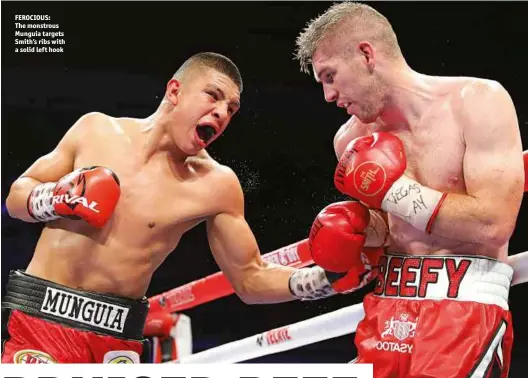  ?? Photos: TOM HOGAN/HOGAN PHOTOS/GOLDEN BOY ?? FEROCIOUS: The monstrous Munguia targets Smith’s ribs with a solid left hook