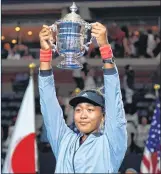  ??  ?? US Open women’s single champion Osaka holds the trophy