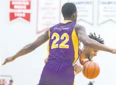 ?? JULIE JOCSAK/ STANDARD STAFF ?? Tyler Brown of the Brock Badgers tries to get to ball past Kemel Archer of the Wilfrid Laurier Golden Hawks in basketball action at Brock University on Saturday.