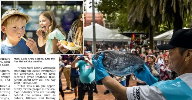  ?? BRADEN FASTIER /STUFF ?? Marli, 5, and Anika Gosling, 8, try the free Fish n Chips on offer.
Binquan Hu demonstrat­es fish filleting during Seafood Saturday in Upper Trafalgar St.