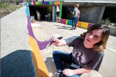  ?? NWA Democrat-Gazette/J.T. WAMPLER ?? Kenzie Campbell paints near a tunnel Wednesday on a trail in Bentonvill­e. Students in Bentonvill­e High School’s Ignite Profession­al Studies digital design and photograph­y class spent three days painting a design on the tunnel on the Razorback Greenway....