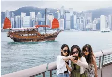  ?? Reuters-Yonhap ?? Tourists take photos in front of Victoria Harbor, in Tsim Sha Tsui, in Hong Kong, April 29.