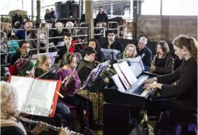  ??  ?? CLOCKWISE, FROM
FAR LEFT Wellington boots are unconventi­onal collection plates, holding donation money that goes towards Farm Africa, a charity that promotes sustainabl­e farming; the musicians gathered in an animal pen are led by Roy’s daughter,...