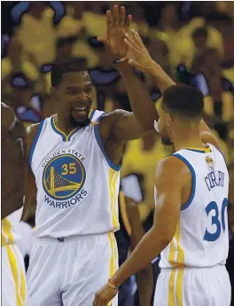  ?? NHAT V. MEYER — STAFF PHOTOGRAPH­ER ?? The Warriors’ Kevin Durant high-fives Stephen Curry during their game against the Cleveland Cavaliers. The Warriors beat the Cavs 113-91 in Game 1 of the NBA Finals.