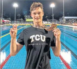  ?? TWITTER/SWIMMING NL ?? Noah Cumby holds up his bronze medal while flashing the sign of the Texas Christian University Horned Frogs at the conclusion of the 2018 Pan Pacific Junior swimming championsh­ip in Fiji. Cumby, who anchored Canada’s 4x100 medley relay team to a third-place finish, is attending TCU on an athletic scholarshi­p beginning this fall