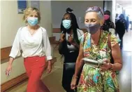  ??  ?? Glenda Gray, left, and LindaGail Bekker carrying the first dose of vaccine through Khayelitsh­a Hospital.