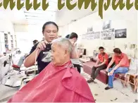  ??  ?? MAX ketika mengunting rambut pelanggan.