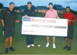  ??  ?? Tiger Woods, right, and former NFL player Peyton Manning, 2nd right, along with Phil Mickelson, left, and NFL player Tom Brady of the Tampa Bay Buccaneers show off the amount their charity golf raised for COVID-19 relief yesterday. (AFP)