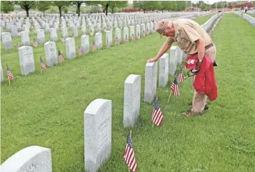  ?? MIKE DE SISTI / MILWAUKEE JOURNAL SENTINEL ?? Veteran Tom Sitter, 96, of Madison visits the grave of his friend Edward Toporsh on Monday at Southern Wisconsin Veterans Memorial Cemetery in Union Grove. They served together in the Army during World War II.