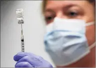  ?? Robert F. Bukaty / Associated Press ?? A syringe is prepared with Pfizer’s COVID-19 vaccine.