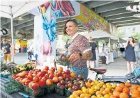  ?? COLE BURSTON FOR THE TORONTO STAR ?? An avid cyclist, Devon Luxmore-Rousset shops at the Underpass Park Farmers’ Market, near her future River & Fifth condo home.