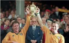  ??  ?? Former Wallabies captain Nick Farr-Jones, pictured lifting the World Cup trophy in 1991, has led a revolt by former test skippers against Rugby Australia’s administra­tion.