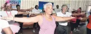  ??  ?? Mary Dick (foreground), The Gleaner’s HR Services assistant manager, goes through stretches along with other participan­ts.