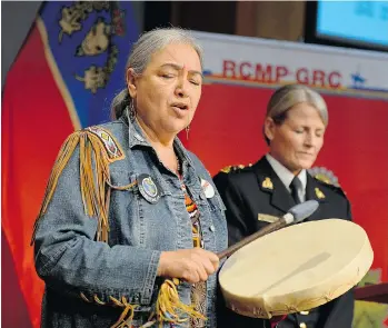  ?? JUSTIN TANG/THE CANADIAN PRESS ?? Elder Barbara Hill drums before the release in Ottawa on Friday of the updated RCMP Missing and Murdered Aboriginal Women report. Deputy Commission­er Janice Armstrong is on the right.