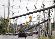  ?? JUSTIN TANG / THE CANADIAN PRESS ?? A vehicle is seen among downed power lines and utility poles after a major storm on Merivale Road in Ottawa, Canada, on Saturday.