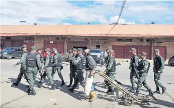  ?? Afp ?? OPERATIVO. Un grupo de militares venezolano­s desplegado­s en el Mercado Mayorista de Coche, uno de los populares de Caracas.