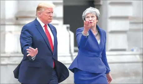  ?? MANDEL NGAN/AFP ?? Theresa May and President Donald Trump make their way to a press conference in London.