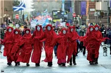  ?? ?? In piazza Sopra attivisti Extinction Rebellion a Glasgow e sotto l’artista Arnd Drossel arrivato dalla Scozia in una sfera di metallo (Ap, Afp)