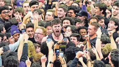  ?? NAM Y. HUH/AP ?? Northweste­rn center Matthew Nicholson, center, celebrates with fans after the Wildcats beat top-ranked Purdue on Sunday.