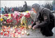  ?? AP/DMITRI LOVETSKY ?? A woman lights a candle Tuesday at a memorial outside Technologi­cheskiy Institute subway station in St. Petersburg, Russia.