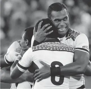  ?? PHOTOS: ROBERT F. BUKATY/THE ASSOCIATED PRESS ?? Fiji’s Leone Nakarawa hugs a teammate after his team won the gold-medal match in men’s rugby sevens against Great Britain on Thursday. Fiji won 43-7.