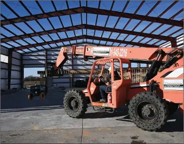  ?? (Arkansas Democrat-Gazette/Stephen Swofford) ?? Workers construct a T-Hangar at Conway Regional Airport on Friday. The hangar currently has a waitlist of over 40 aircraft owners hoping to rent one of the 12 new spaces it will provide, said Conway Airport director Jack Bell.