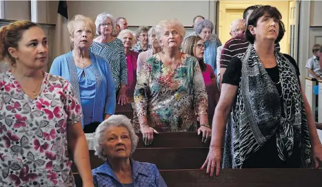  ?? PHOTOS: MICHAEL S. WILLIAMSON/THE WASHINGTON POST ?? Congregant­s follow along with a projection of a Bible verse during a sermon at the First Baptist Church in Luverne, Ala., by its pastor, Clay Crum, in his series on the Ten Commandmen­ts.