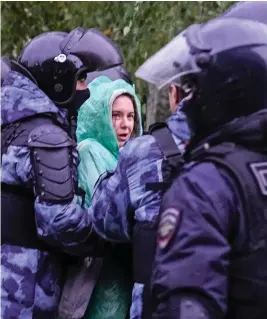  ?? ?? Shouts of protest: Women are dragged from a rally in Moscow by police in riot gear. Around 50 were detained