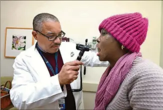  ?? CONTRIBUTE­D BY PHIL JONES / AUGUSTA UNIVERSITY ?? Dr. Jeremy Mark A. Pantin examines Alexis Jones-Heggs during a follow-up visit at Augusta University Health. Jones-Heggs is one of the first adults to receive a bone marrow transplant as part of a National Institutes of Health-funded trial of a...