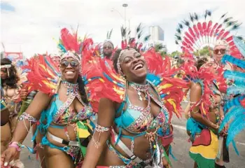  ?? TIJANA MARTIN/THE CANADIAN PRESS ?? Feathered and beaded participan­ts perform Saturday during the Grand Parade at the Caribbean Carnival in Toronto. The annual event resumed in the city after a two-year hiatus due to the COVID-19 pandemic.