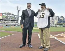  ?? Matt Freed/Post-Gazette ?? Pirates president Frank Coonelly honors usher Phil Coyne on the field Wednesday at PNC Park. Mr. Coyne turned 99 on Thursday. To watch a video, visit post-gazette.com.