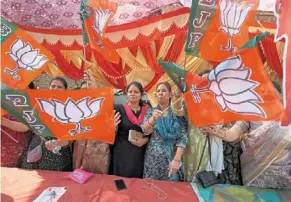  ?? — ap ?? Party under fire: BJP supporters waving their party flags, which uses a lotus as its election symbol, ahead of the second phase of national elections in Meerut.