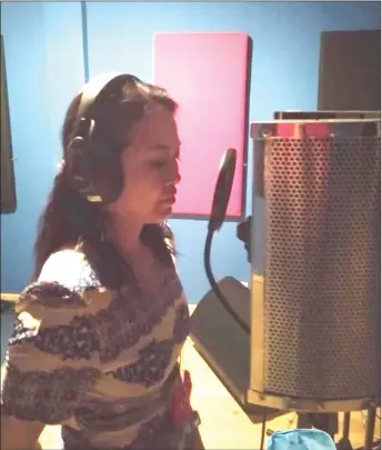  ??  ?? Bidayuh singer Jenny doing voice recording for a new song at MPH studio in Serian.