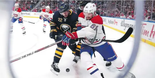  ?? KEVIN HOFFMAN/GETTY IMAGES ?? The Sabres’ Johan Larsson and the Canadiens’ Xavier Ouellet battle for the puck Thursday during the Sabres’ 4-3 victory in Buffalo.