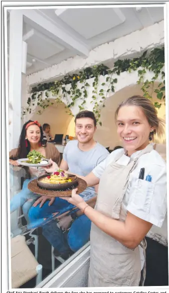  ?? Picture: GLENN HAMPSON ?? Chef Ana Stephani Baralt delivers the fare she has prepared to customers Catalina Cortes and Gabriel Monica at Milkman’s Daughter.