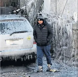  ?? JIM MAHONEY / HERALD STAFF ?? WHAT HAD TO BE DONE: Sophear Chau walks amid the ice and debris from the fire that destroyed his family’s three-story home on Grover Street in Lynn on Thanksgivi­ng night.