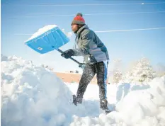  ?? BRYON HOULGRAVE/DES MOINES REGISTER ?? Bonny Obutu shovels snow Saturday in West Des Moines, Iowa.