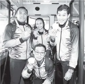  ??  ?? BANGGA: Mohd Ziyad, Mohamad Riduan, Abdul Latif dan Siti Noor Radiah tersenyum bangga menunjukka­n pingat emas dan gangsa yang dimenangi pada Sukan Paralimpik Rio 2016 sejurus tiba di Lapangan Terbang Antarabang­sa Kuala Lumpur ( KLIA) kelmarin. - Gambar...