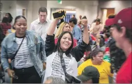 ?? Allen J. Schaben Los Angeles Times ?? A WOMAN celebrates at the June 18 L.A. school board meeting after members vote to end the much-criticized practice of random searches of students.