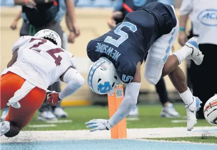  ?? ROBERT WILLETT/ASSOCIATED PRESS ?? UNC’s Dazz Newsome, a Hampton High graduate, hurdles into the end zone near Virginia Tech’s Devin Taylor (24) for one of his two touchdowns.