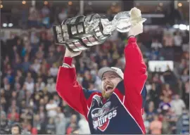  ?? The Canadian Press ?? Windsor Spitfires forward Aaron Luchuk, who scored the game-winning goal, raises the trophy after defeating the Erie Otters to win the Memorial Cup in Windsor, Ont., on Sunday.