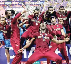  ?? FILE ?? Members of the West Indies senior men’s and women’s teams celebrate together after winning their respective finals of the ICC World Twenty20 and Women’s World Twenty20 cricket tournament­s last year.