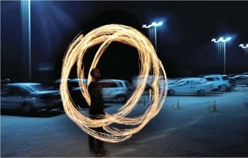  ?? Picture: BRYAN SMITH ?? FIRE NOT FIREWORKS: Skyelar Dacombe performs fire poi in the Guido’s Beach Bar parking lot on Guy Fawkes night, instead of fireworks, to raise support for the Port Alfred SPCA.